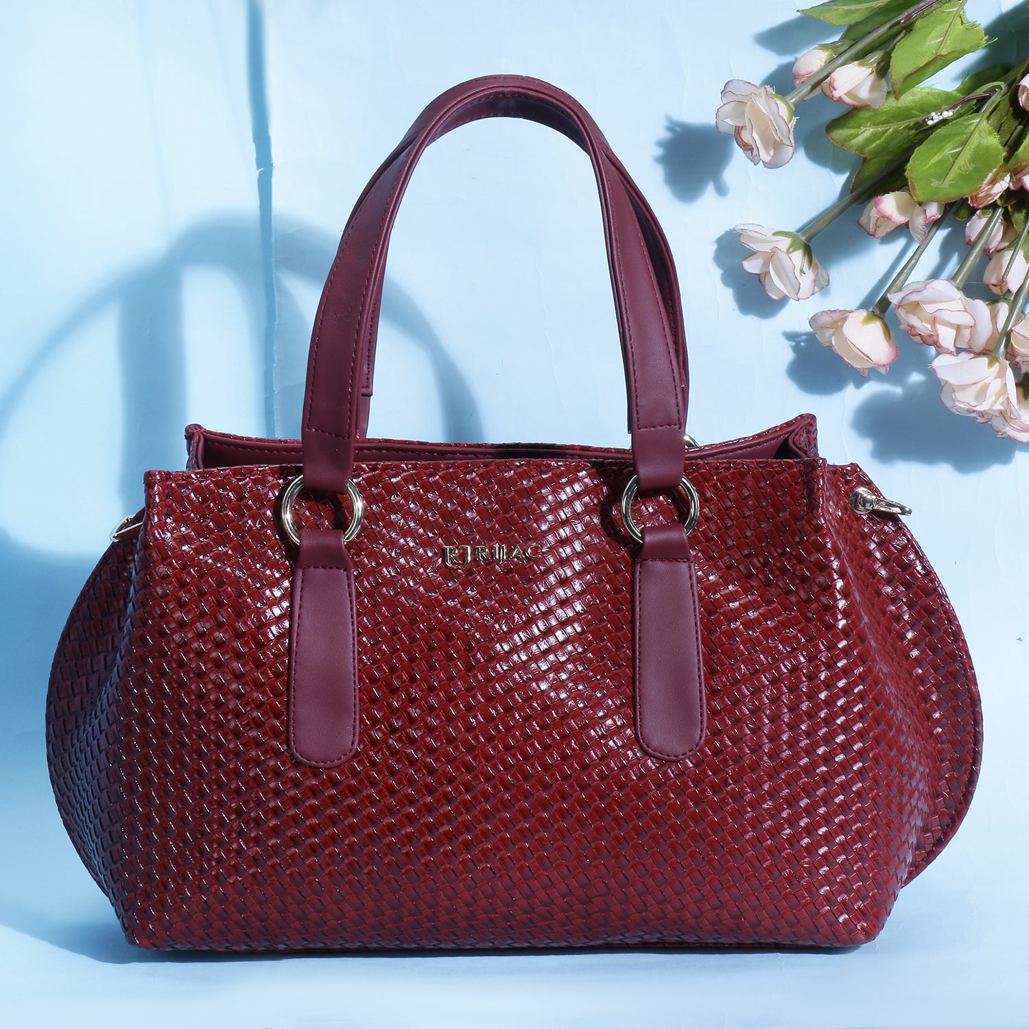 A red woven handbag on a blue background.